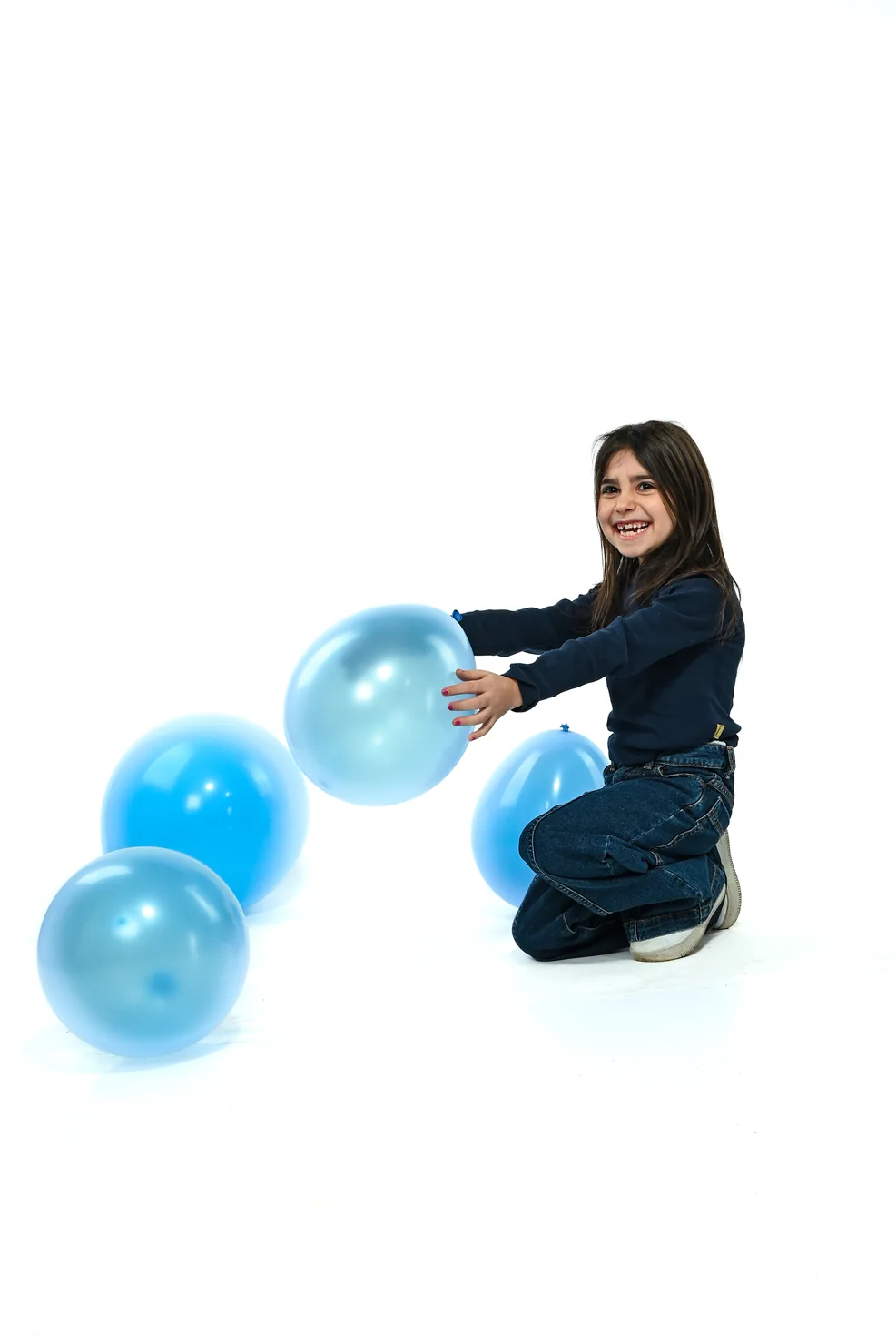 Gaia gioca con piccoli palloncini azzurri