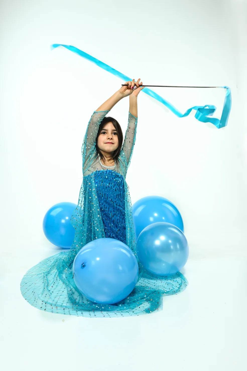 Gaia solleva un nastro azzurro in uno studio fotografico